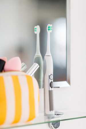 electric toothbrush on mirror shelf in bathroomの写真素材