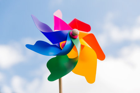 close up of multicolored pinwheel over blue sky