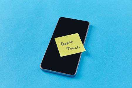 smartphone with dont touch words on sticky noteの写真素材