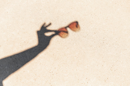 shadow of hands holding sunglassesの写真素材