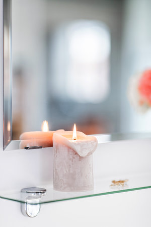 close up of candle on mirror shelf in bathroomの写真素材