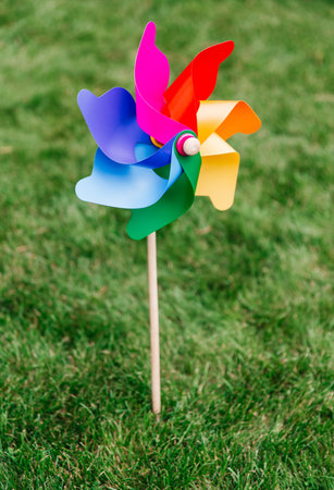 close up of multicolored pinwheel stuck in lawnの写真素材
