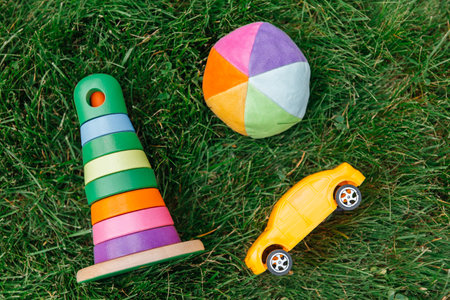 close up of toy car, ball and pyramid on grassの写真素材