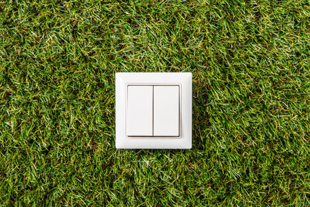close up of light switch on green grass backgroundの写真素材
