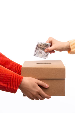hand putting dollar cash money into donation boxの写真素材