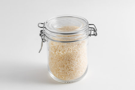 close up of jar with rice on white tableの写真素材