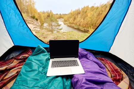 view to river from camp tent with sleeping bagsの写真素材