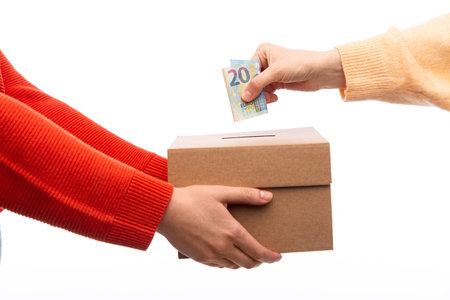 hand putting euro cash money into donation boxの写真素材