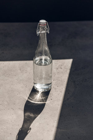 glass bottle of water on sunny floorの写真素材