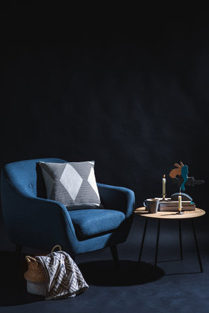 chair, table and blanket in basket in dark roomの写真素材
