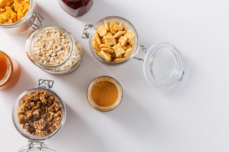 close up of jars with oat, corn flakes and granolaの写真素材