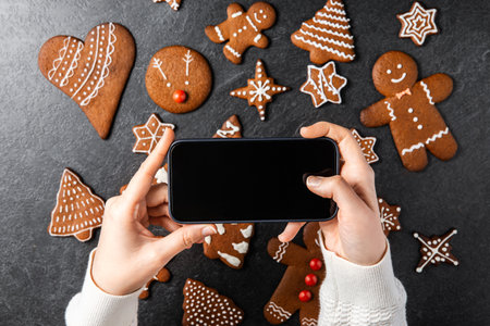close up of hand with smartphone and gingerbreadの写真素材