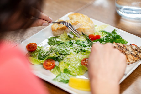 close up of woman eating at restaurantの写真素材