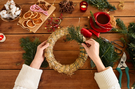 woman making fir christmas wreath at homeの写真素材
