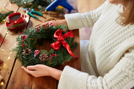 woman holding handmade christmas wreath at homeの写真素材