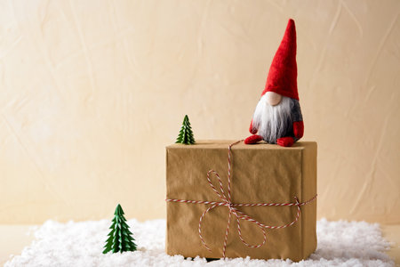close up of christmas gnome and gift box on snowの写真素材