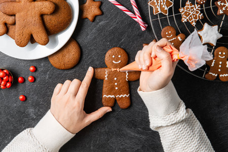 close up of hands icing gingerbread cookiesの写真素材