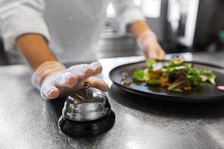 close up of chef ringing bell at restaurantの写真素材