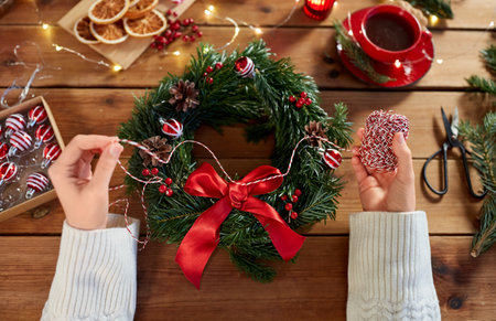 woman making fir christmas wreath at homeの写真素材