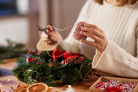 woman making fir christmas wreath at homeの写真素材