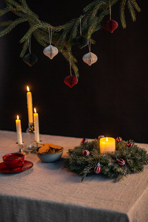 christmas wreath, gingerbread and candles on tableの写真素材