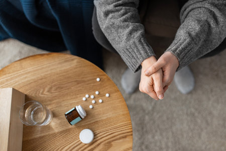 close up of stressed woman with medicine at homeの写真素材