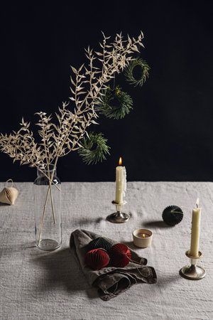 fir branch with christmas toys and candle on tableの写真素材