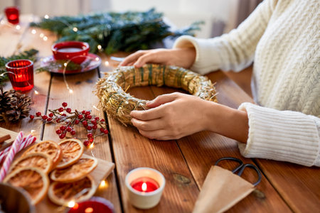 woman making fir christmas wreath at homeの写真素材