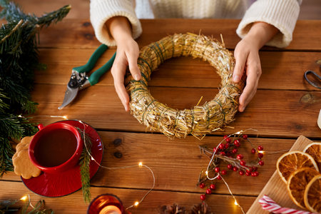 woman making fir christmas wreath at homeの写真素材