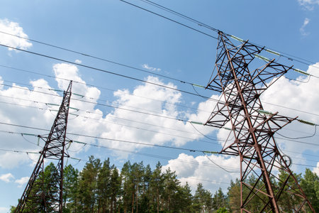 transmission tower and power line over blue skyの写真素材