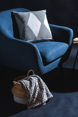 blue chair and blanket in basket over black wallの写真素材