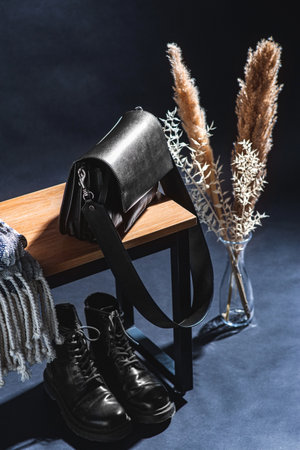 blanket on bench, boots and bag in dark roomの写真素材