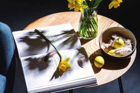 easter eggs, daffodils and magazine on tableの写真素材