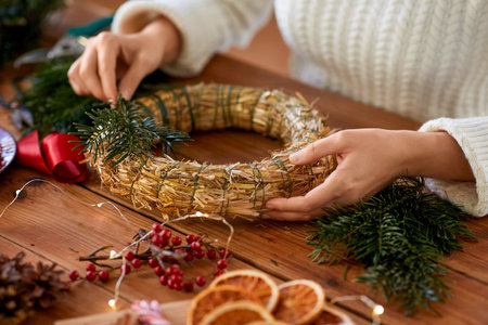 woman making fir christmas wreath at homeの写真素材