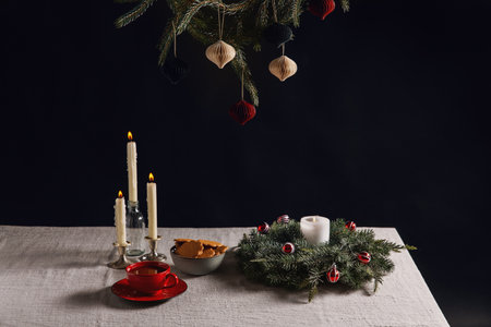 christmas wreath, gingerbread and candles on tableの写真素材