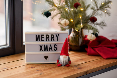 merry christmas on light box and gnome on windowの写真素材