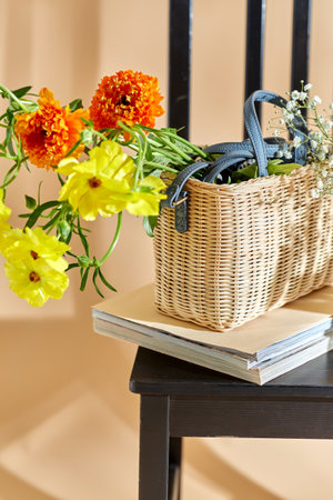 flowers in basket on chair over beige backgroundの写真素材