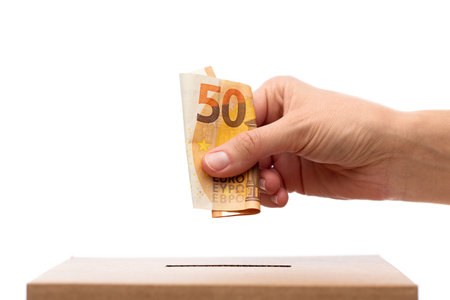 hand putting euro cash money into donation boxの写真素材