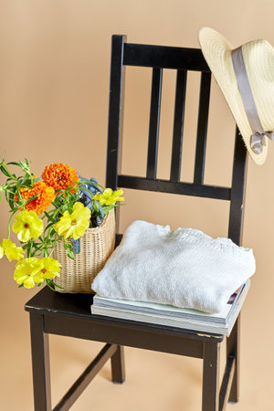 flowers in basket, clothes and hat on old chairの写真素材