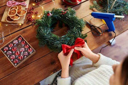 woman making fir christmas wreath at homeの写真素材