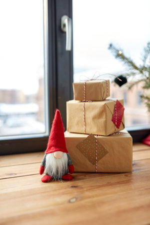 christmas gifts, gnome and fir branches on window