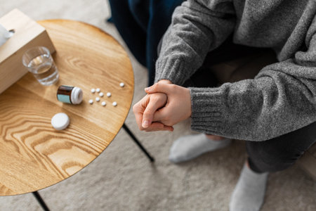 close up of stressed woman with medicine at homeの写真素材