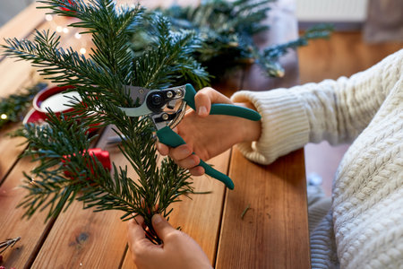 happy woman making fir christmas wreath at home