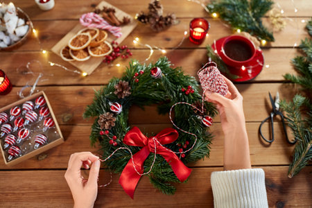 woman making fir christmas wreath at homeの写真素材