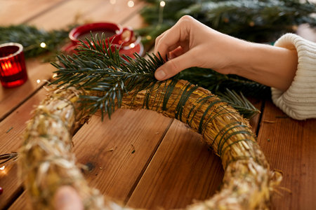 woman making fir christmas wreath at homeの写真素材