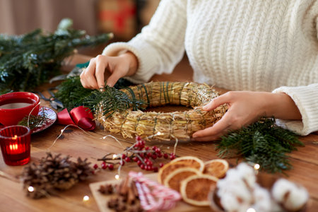 woman making fir christmas wreath at homeの写真素材