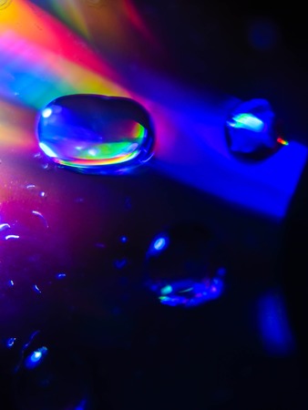 Spreading water drops on cd disk. Rainbow.の写真素材