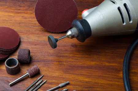 Mini drill with various nozzles and cutters on a white background