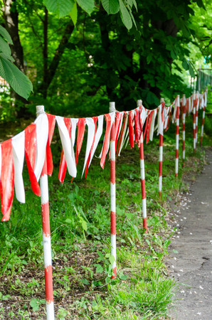 Red and white barrier tape blocking the way.の写真素材