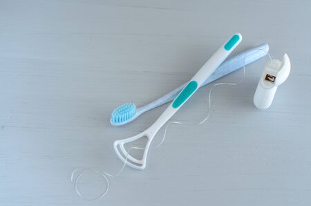 Oral hygiene health concept. Closeup dental tools toothbrush, dental floss and tongue cleaner.
